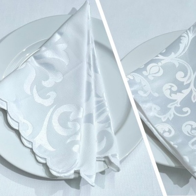 Guardanapo branco com padrão floral em relevo sobre prato branco