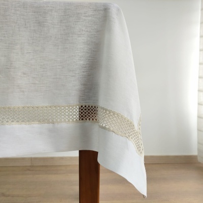 Toalha de mesa branca com faixa rendada bege numa mesa de madeira