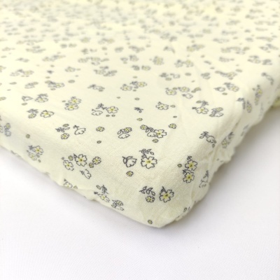 Colchão para bebé com padrão floral amarelo e cinzento sobre fundo branco