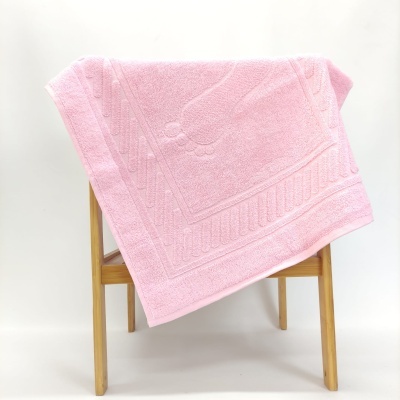 toalha rosa felpuda com padrão em relevo numa estrutura de madeira