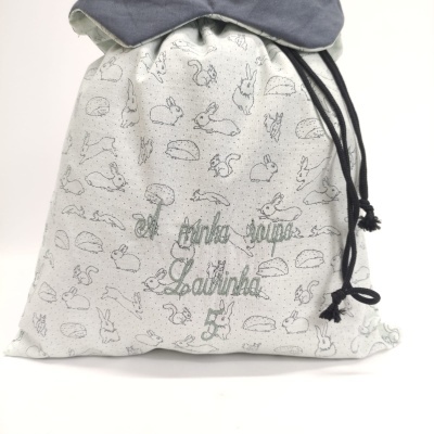 Saco de tecido com padrão de animais e texto bordado