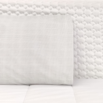 Capa de almofada branca com padrão quadriculado preto sobre almofada branca acolchoada