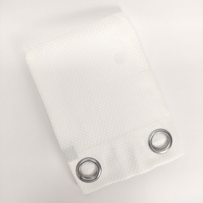 Rede branca dobrada com dois ilhós metálicos numa extremidade