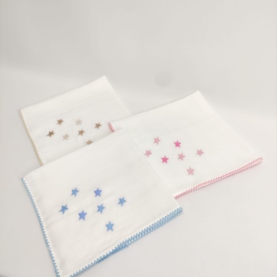 Três panos brancos com estrelas bordadas em azul, rosa e bege e bordas decorativas