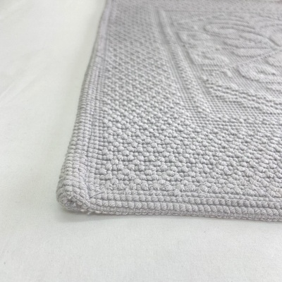 Tapete cinzento claro com padrão geométrico em relevo e bordas arredondadas