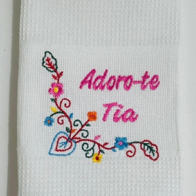 Toalha bordada branca com texto e flores coloridas