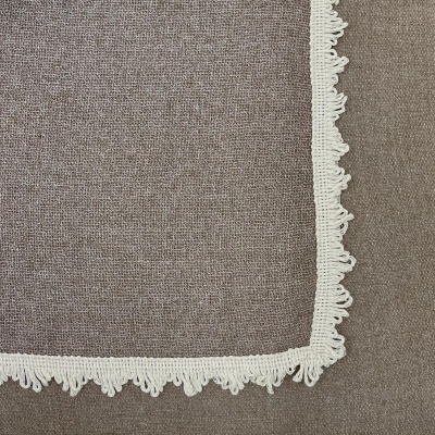 tecido castanho com peça de tecido branco com renda nos bordos