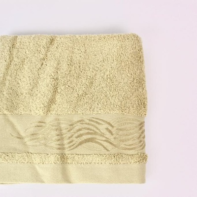 Toalha de banho bege claro com faixa decorativa ondulada