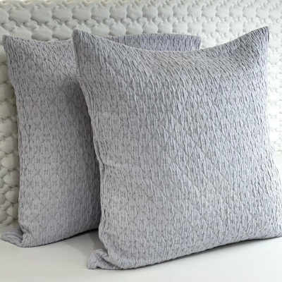 Dois almofadas cinzentas com padrão trançado e textura de malha