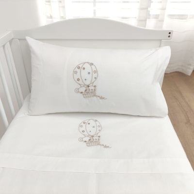 Jogo de cama branco com bordado de balão e gatinhos em berço branco