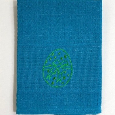 Toalha azul com bordado verde de ovo e fita