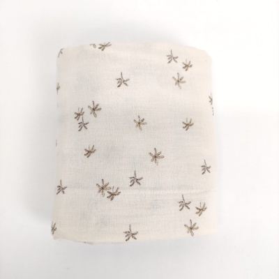 Fralda branca com desenhos castanhos de estrelas ou flores