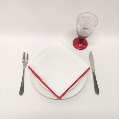 Utensílios de mesa com guardanapo branco e copa vermelha