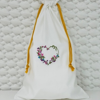 Saco branco com bordado de coração e cordões amarelos