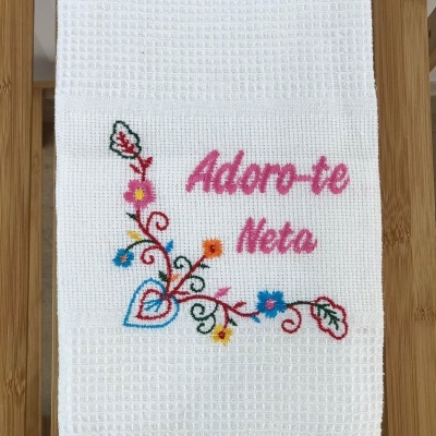 Toalha branca com bordado colorido e texto 'Adoro-te Neta'