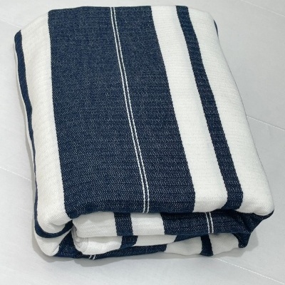 Manta dobrada com riscas brancas e azuis escuras