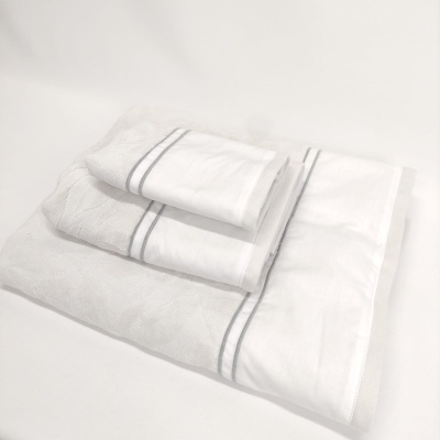 Conjunto de toalhas brancas com risca cinzenta sobre fundo branco