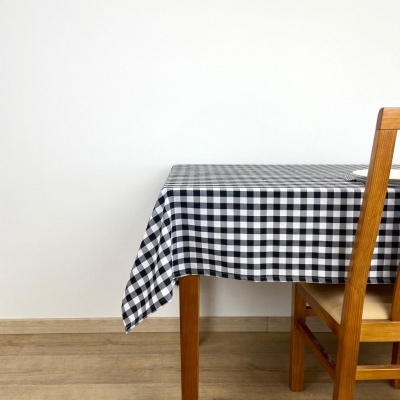 Mesa de madeira com toalha xadrez preta e branca e cadeira de madeira