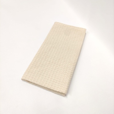 Guardanapo de tecido bege claro com padrão em relevo