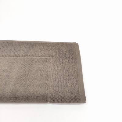 Toalha de banho cinzenta dobrada com textura felpuda