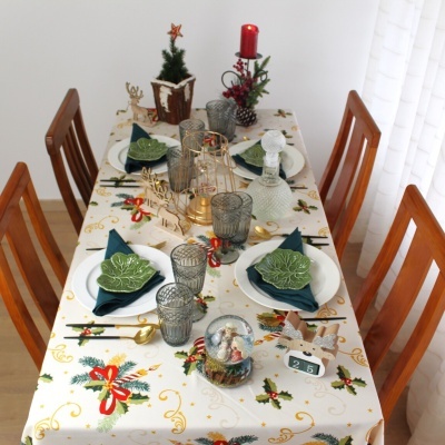 Mesa decorada para jantar de Natal com toalha estampada e acessórios festivos