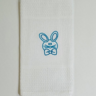 Toalha branca com bordado azul de coelho e textura quadriculada