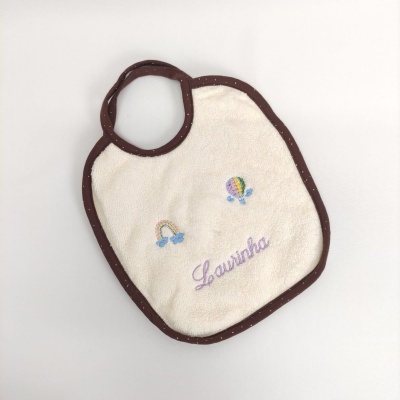 Babete para bebé branco com bordas castanhas e bordados coloridos