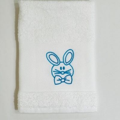 Toalha branca com bordado azul de coelho e laço