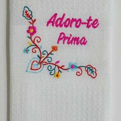 Toalha branca com bordado colorido e texto 'Adoro-te Prima'