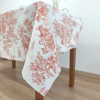Toalha de mesa branca com padrão vermelho sobre mesa de madeira