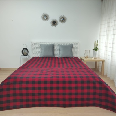 Cama dupla com manta xadrez vermelha e preta em quarto com decoração minimalista