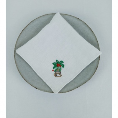 Guardanapo branco bordado com sino e folhas verdes sobre prato cinzento