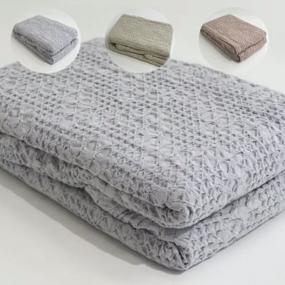 Mantinhas de tecido com textura em relevo em cores cinza, bege e rosa.