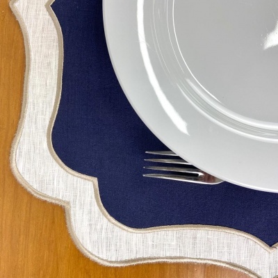 Jogos americanos branco e azul sob prato branco e garfo em madeira