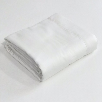 Lençol branco dobrado sobre superfície branca