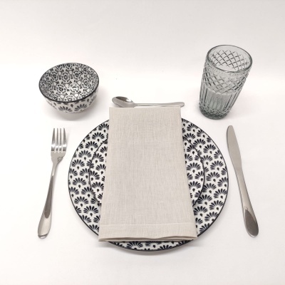 Conjunto de prato, tigela, talheres, guardanapo e copo para mesa em fundo branco.