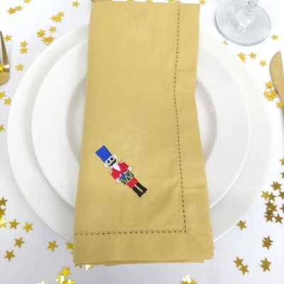 Guardanapo amarelo com bordado de soldado de brinquedo na mesa festiva