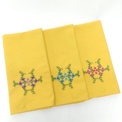 Conjunto de três panos de cozinha amarelos com bordados florais coloridos