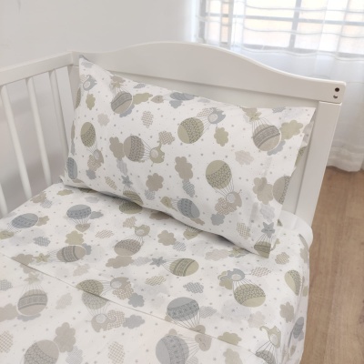 roupa de cama para berço com padrão de balões de ar quente em tons neutros