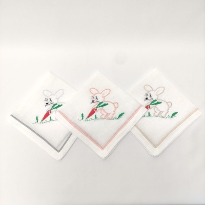 Três panos de boca brancos com bordado de coelho e bordas coloridas