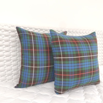 Duas almofadas quadradas padrão riscas coloridas sobre colcha branca acolchoada