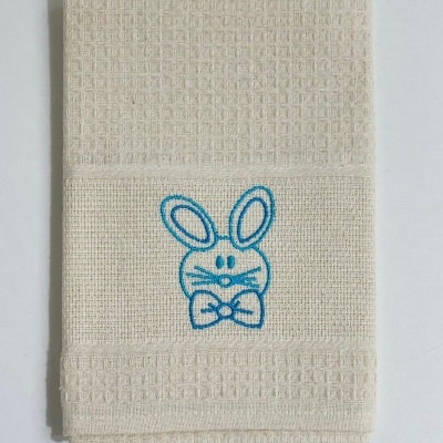 Toalha bege claro com bordado de coelho azul