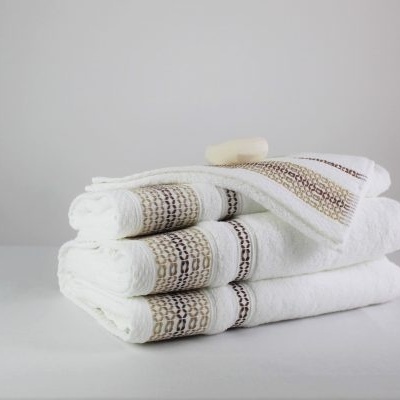 Conjunto de três toalhas brancas decoradas com faixas coloridas, empilhadas sobre superfície branca