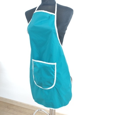 Avental azul turquesa com bolso branco num manequim preto