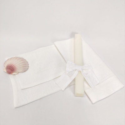 Toalha branca em algodão com vela branca e laço e concha decorativa