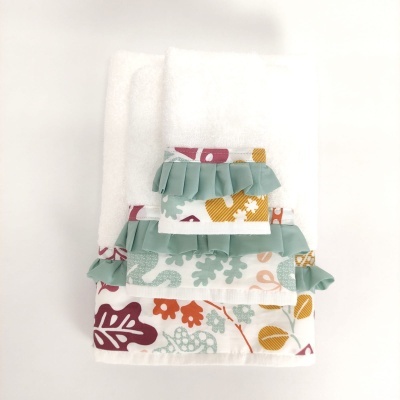 Conjunto de toalhas brancas com franjas verdes e estampas florais coloridas