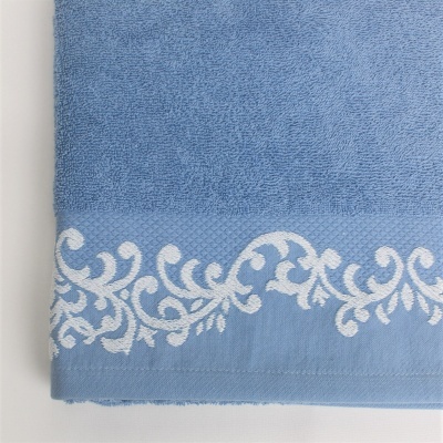 Toalha azul com bordado branco floral na barra
