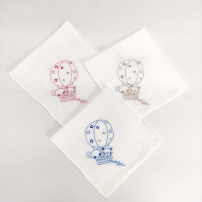 Três panos brancos com bordados coloridos de balão de ar quente e urso.