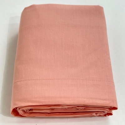 Lençol cor-de-rosa dobrado em tecido liso sobre fundo branco