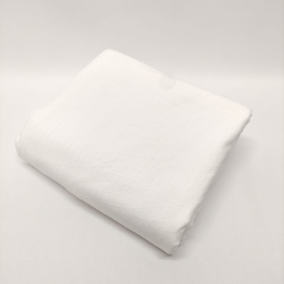 tecido branco dobrado sobre superfície branca